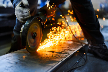 Metal plate cutting with abrasive disk and splashing sparks - obrazy, fototapety, plakaty