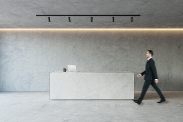 Side view of young businessman walking in modern concrete office reception interior with desk. Lobby concept. Worker and CEO concept.