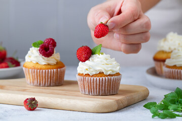 Hand decorating cupcakes with berries,  Part 8/9