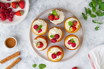 Cupcakes with raspberries and strawberries, top view