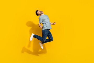 Fototapeta na wymiar Full length portrait of delighted astonished man jumping celebrate accomplishment isolated on yellow color background