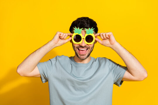 Closeup photo of young crazy funky positive man wear sunglass good mood hold spectacles summer chill vacation relax isolated on yellow color background