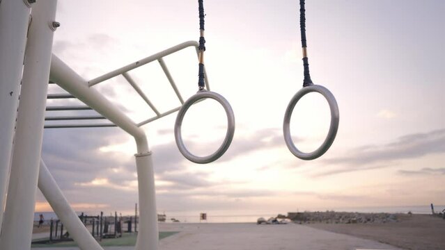 Young athlete doing Calisthenic and gymnastic exercises at the beach at sunrise