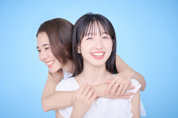 白い服を着て写真に収まる女性2人
