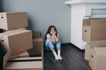Sad woman sitting with boxes goes through divorce, property division. Eviction, removal and stress