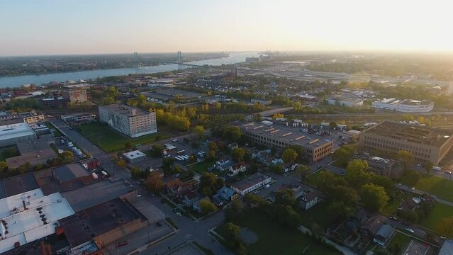 Drone footage of downtown Detroit Michigan along the Detroit River and Ambassador Bridge at sunset