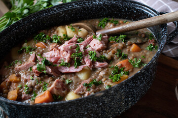 Legume stew with brown lentils, vegetables, potatoes and smoked pork meat