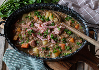 Lentil stew with pork meat in a rustic pot
