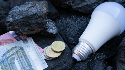 Euro currency, LED lamp on the background of fossil coal.Green energy concept