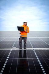 Solar power plant engineer standing on the rooftop with laptop computer and checking electricity production. © littlewolf1989