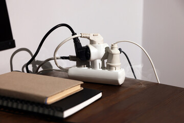 Smoking plug in power strip on wooden table. Electrical short circuit