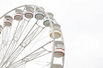 Large white observation wheel against sky, space for text