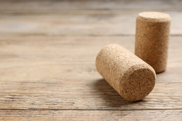 Corks of wine bottles on wooden table, closeup. Space for text