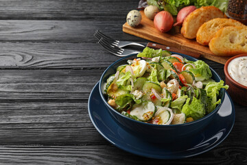 Bowl of delicious cucumber salad served on black wooden table. Space for text