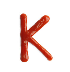 Letter K written with ketchup on white background