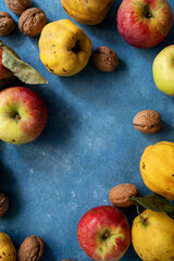 Autumn fruits apples and quinces fruits on blue background, top view, copy space