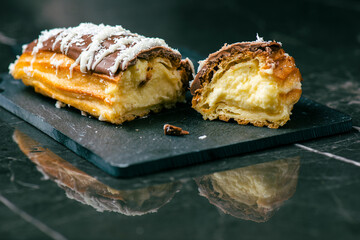 Home-made Eclair with mango and coconut whipped cream. Dipped in milk chocolate.