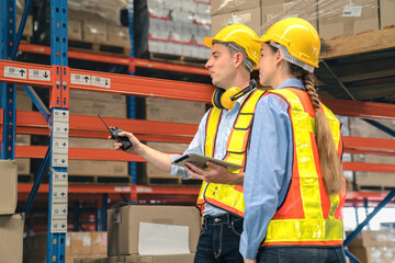Caucasian man, woman warehouse supervisor discuss and use tablet check package with forklift driver...