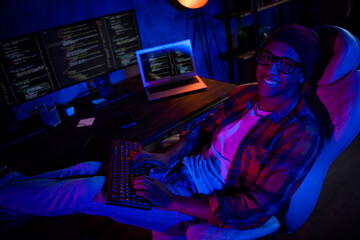 Photo of positive trader guy sit chair keyboard typing optimization microsoft late evening inside