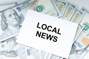LOCAL NEWS - business concept, a card with text on the background of dollar bills