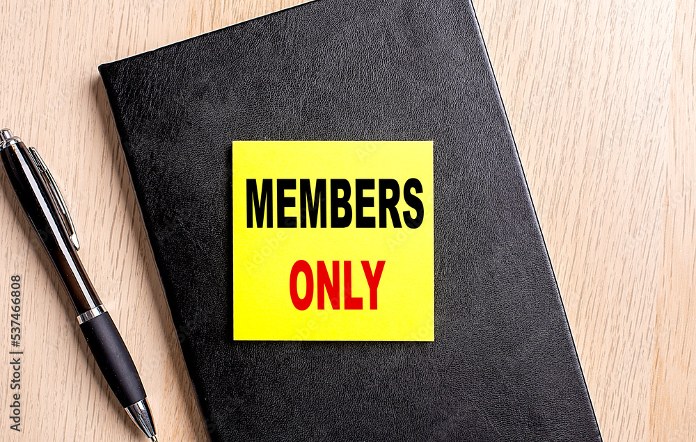 Poster members only text on a sticky on black notebook with pen