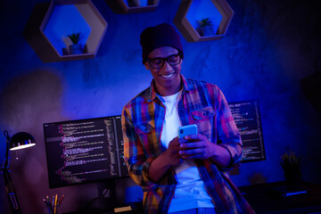Photo of smart hacker guy hold use telephone server security operating evening workstation room...