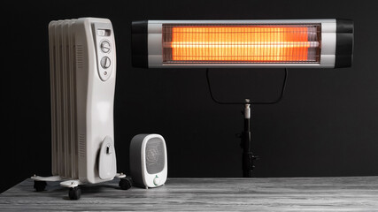 Modern electric infrared, oil and fan heater in living room
