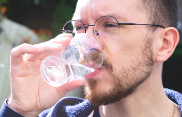 young man drinks water. health care