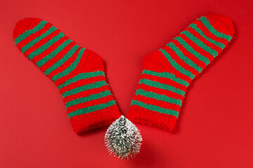 A pair of green striped Christmas socks and a Christmas tree, lying like elk antlers, concept