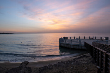 Fototapeta premium the roundabout overlooking the sea and the beach of Avola with the splendid colors of sunrise