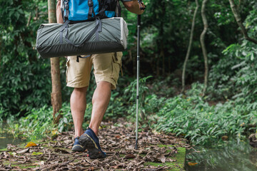 Close up legs of tourist walking through green jungle. Travel, Hiking, Trekking concept.