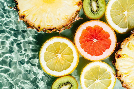 Colorful abstract image of fruit citrus lemon, kiwi, orange, pineapple, grapefruit, lemon, pomelo in water. Flat lay