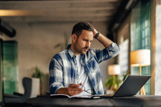 Businessman having a trouble at work, using a laptop, working on