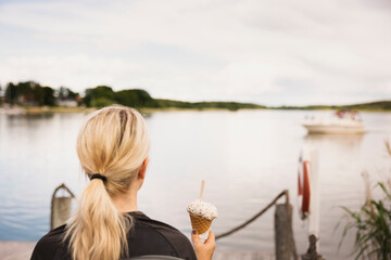 Woman having ice-cream at lake