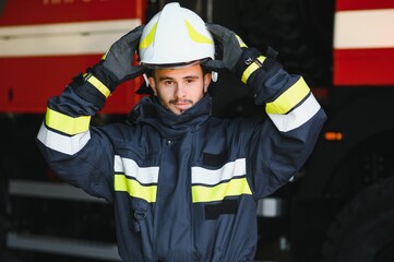 Fototapeta premium Photo of fireman with gas mask and helmet near fire engine