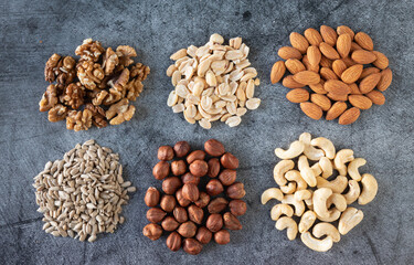 Mix of nuts on a dark background. Food backdrop with nuts and seeds.