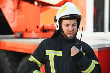 Photo of fireman with gas mask and helmet near fire engine