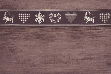 black christmas ribbon with symbols on wooden background with copy space