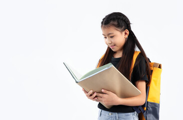Naklejka premium Elementary school kid in private uniform standing and reading book on white background. Back to school.