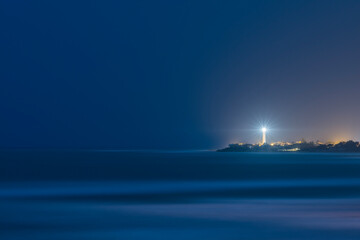 Faro di notte su mare calmo