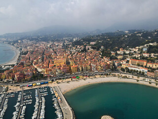 Fototapeta premium Aerial view of Menton in French Riviera from above. Drone view of France Cote d'Azur sand beach beneath the colorful old town of Menton. Small color houses near the border with Italy, Europe.