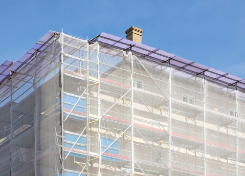 Scaffolding on house facade, apartment builing under construction