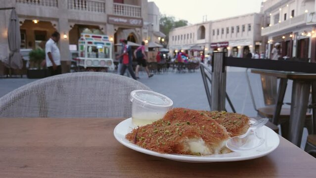 Turkish dessert kunefe, kunafa, kadayif with pistachio powder and cheese, served hot, very sweet