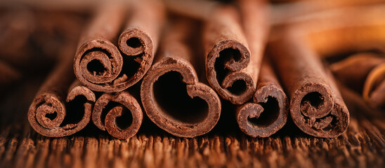 Cinnamon sticks close up. Wooden old table Side view, selective focus. Christmas spice. Banner