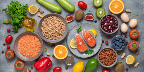 Healthy balanced food. Salmon, cereals, fruits, vegetables, seeds. Clean organic food. Top view, flat lay, copy space. Gray concrete background. Banner