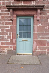 Part glazed wooden Georgian style front door in pale green - 537484418