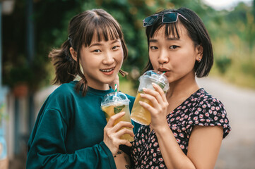 Two girls drinking lemonade and looking pleased