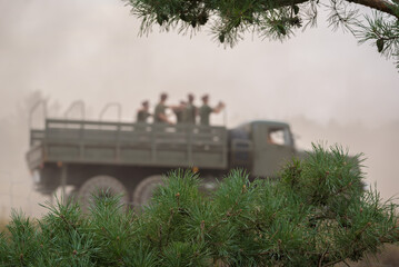 MILITARY VEHICLE ON BACKGROUND OF PINE BRANCHES - Old Russian truck at the shows of military...