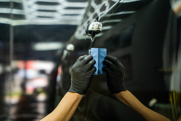 Man's hand is cleaning car at garage