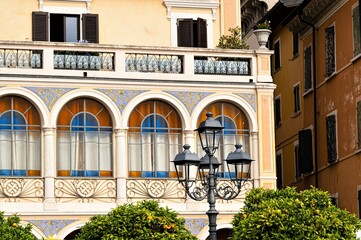 Herrschaftliche Fenster einer Villa mit historischer Straßenlaterne im Ort Salo am Gardasee